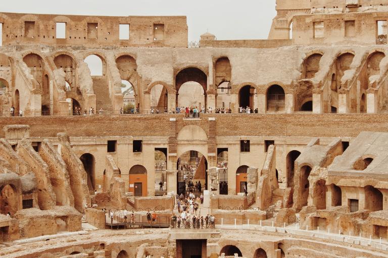 a group of people inside a former seating area in the colosseum