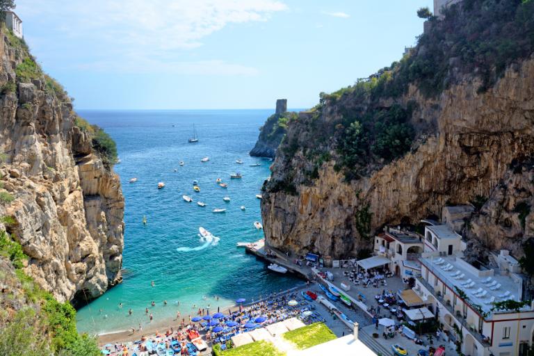 a beach with boats and a body of water