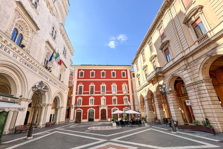 Square in Chieti with ornate buildings and patio tables