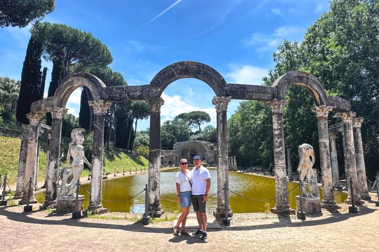 Amongst Romans Home 6 Couple in front of an outdoor pond with columns in Tivoli
